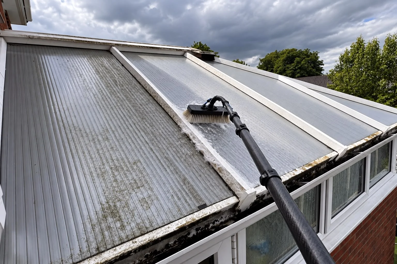 Water-fed brush cleaning a conservatory roof and glazing