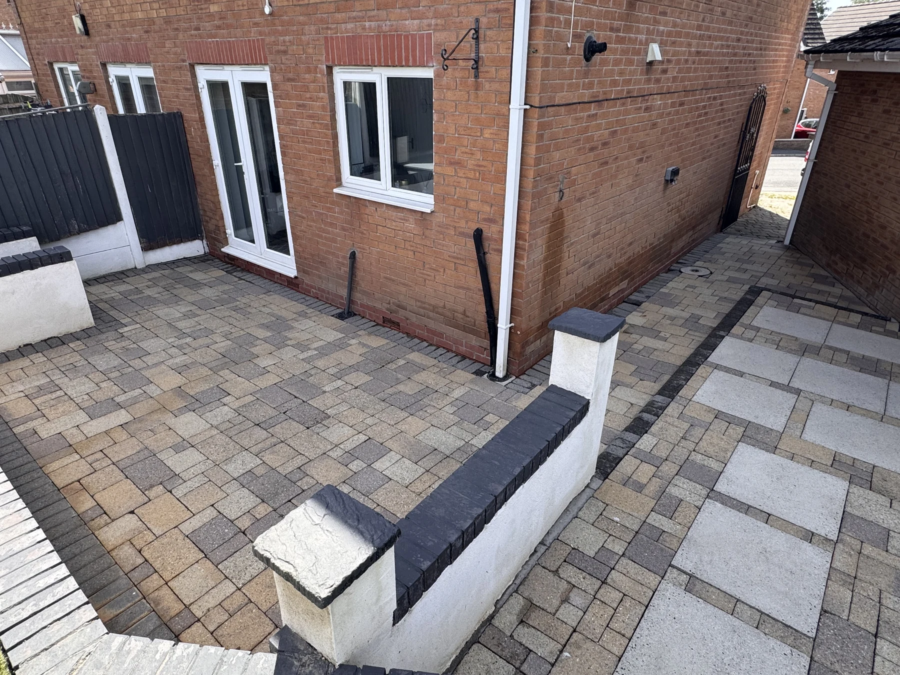 The same patio beside a brick home after professional cleaning