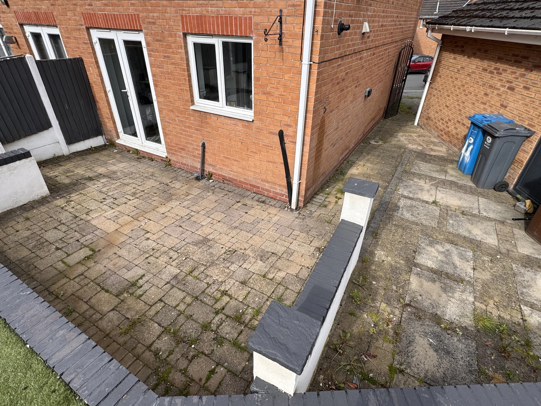 Weathered patio beside a brick home before professional cleaning