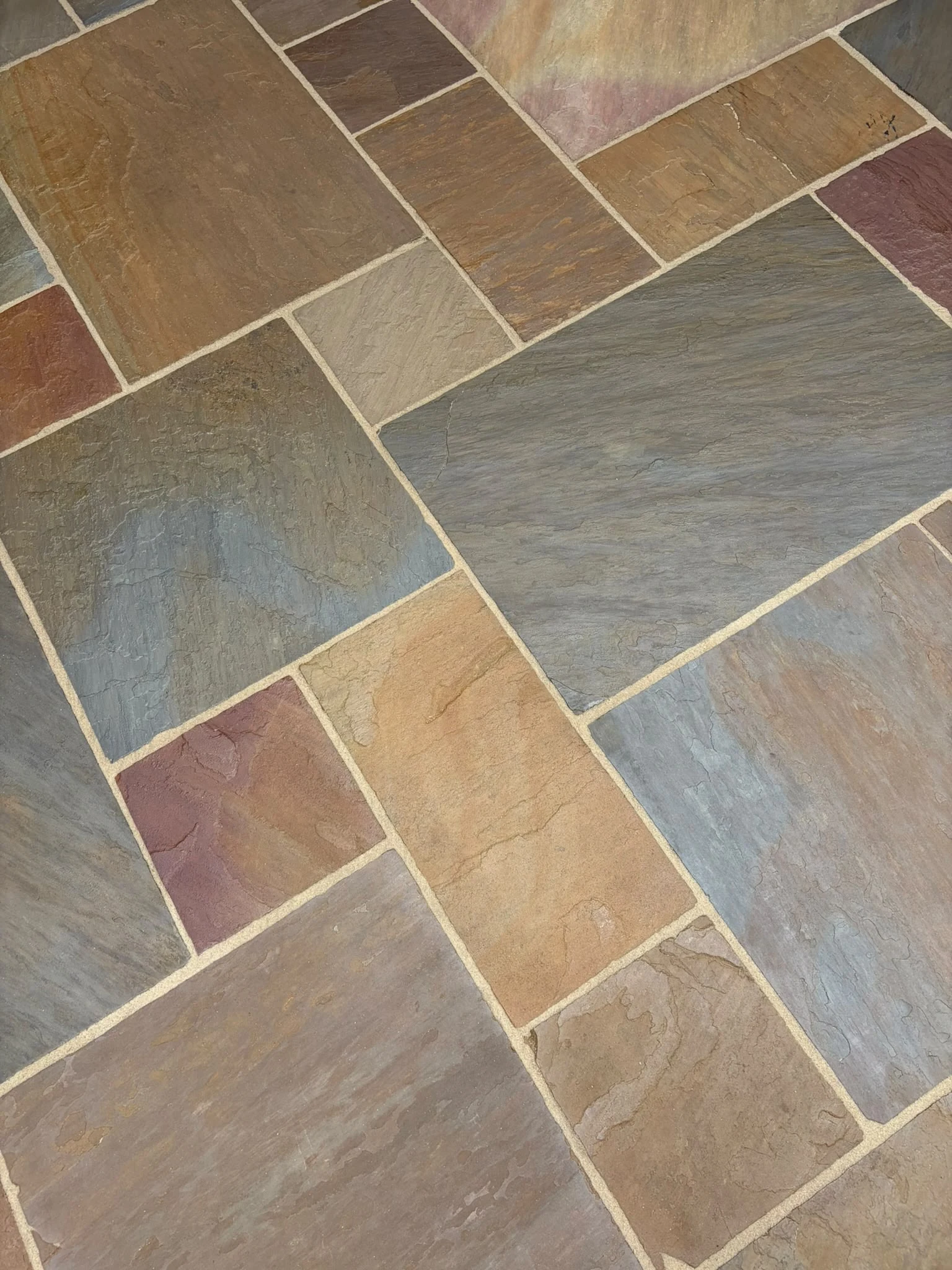 Freshly cleaned natural stone patio slabs after professional cleaning