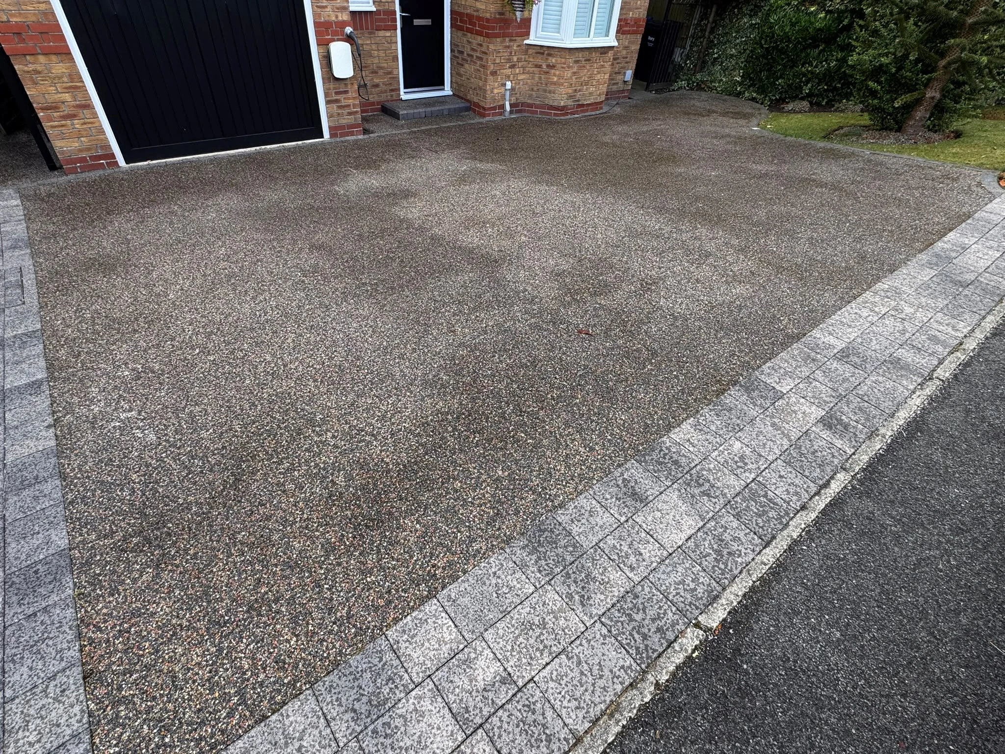 Cleaned resin driveway outside the same brick home after professional exterior cleaning